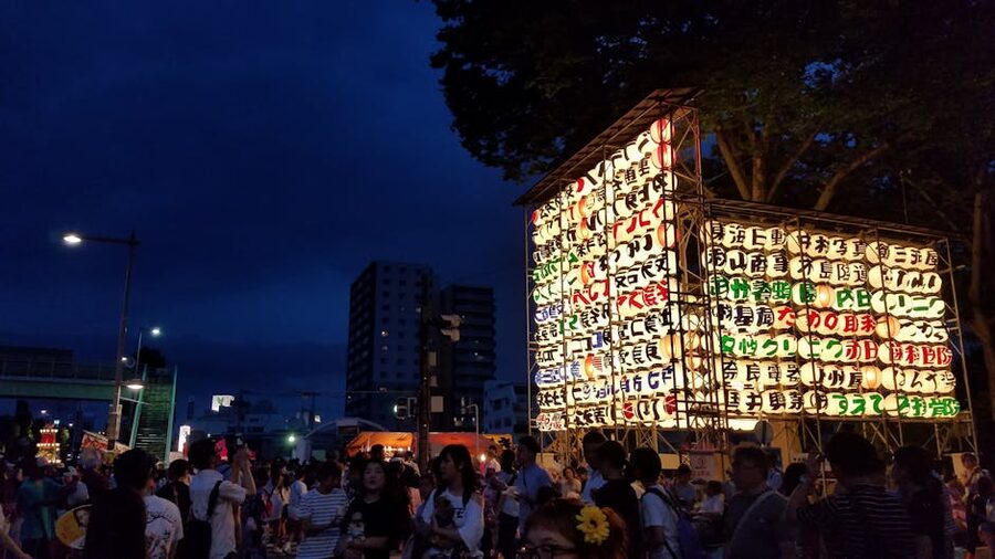 Japanese festival lanterns glowing at a matsuri at night