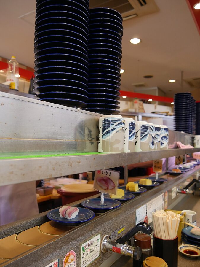 Stacked empty sushi plates at a kaiten-zushi restaurant