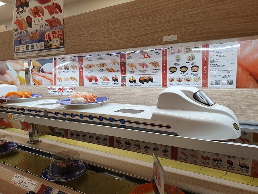 Shinkansen-shaped conveyor delivering sushi plates at a kaitenzushi restaurant