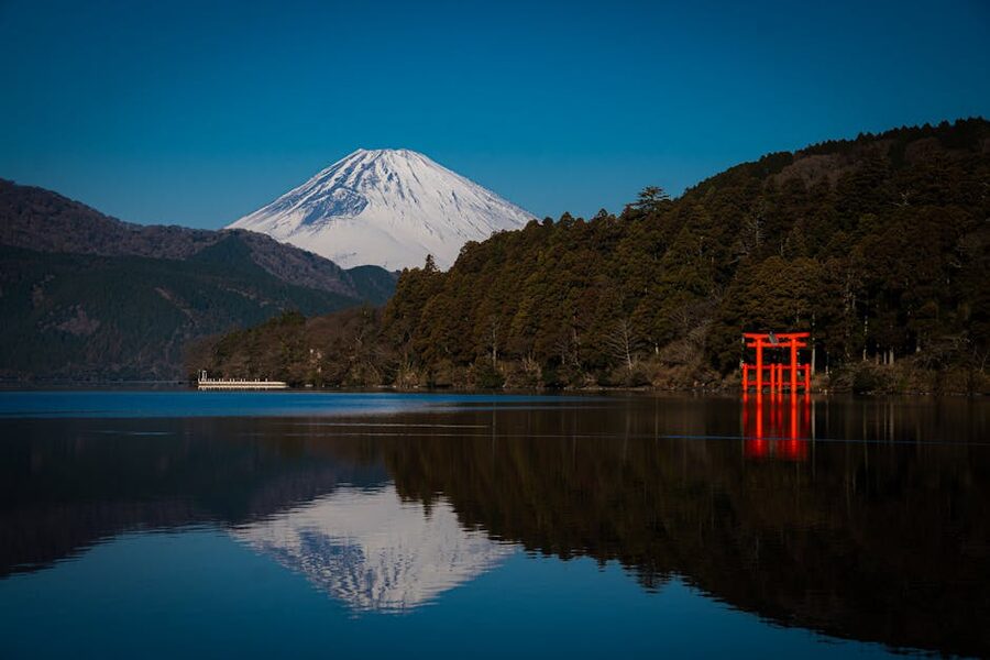 Mount Fuji and the red torii of Hakone-jinja reflected in Lake Ashi on a clear morning