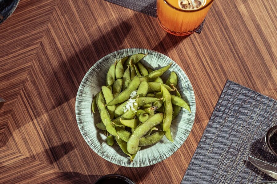 Bowl of fresh edamame with salt on wooden table Japan