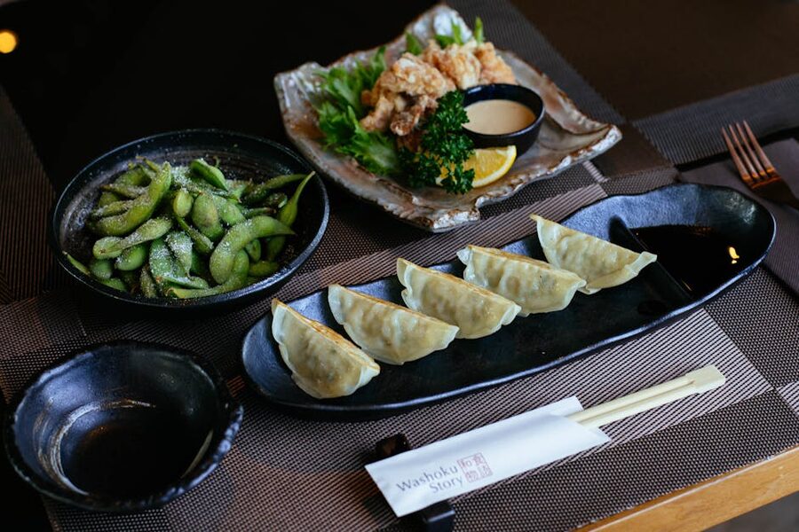 Japanese food including karaage gyoza and edamame on plates
