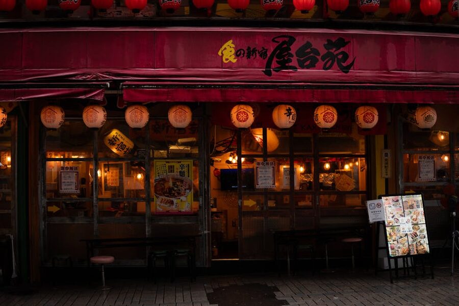 Japanese izakaya exterior with red chochin lanterns at night in Tokyo