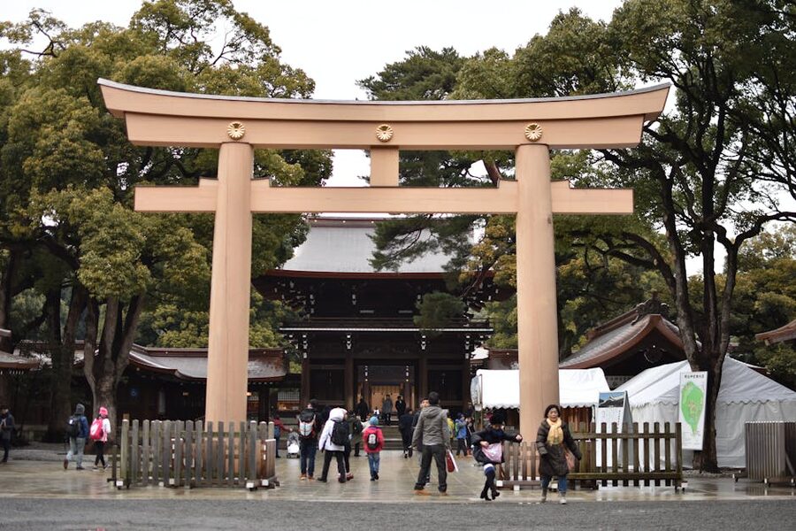 Visitors walking under the main torii gate at Meiji Jingu