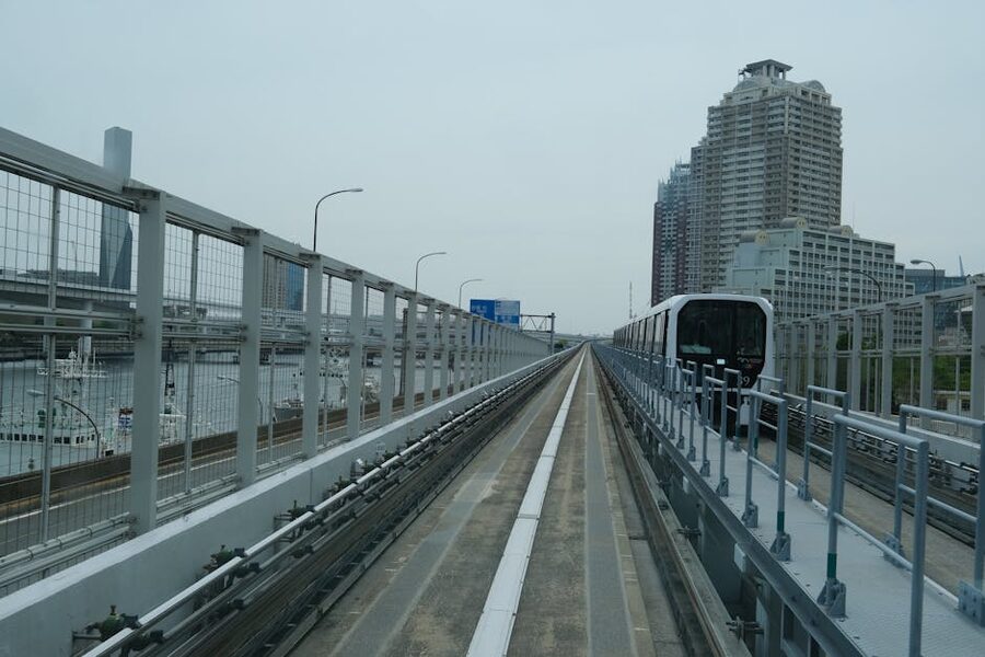 Yurikamome driverless monorail train passing Tokyo skyline Odaiba