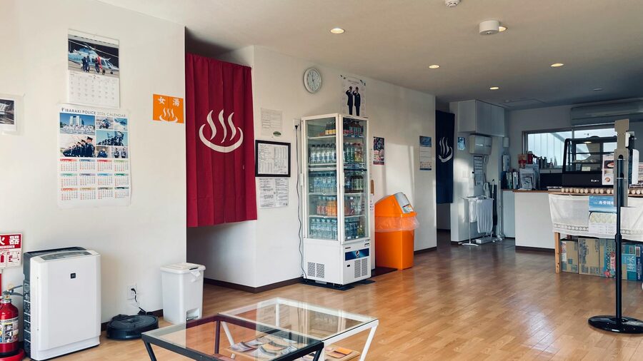 Reception area of a Japanese onsen with vending machines and wooden locker tags