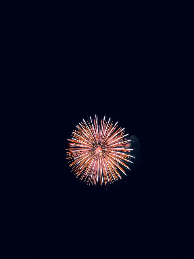 Japanese fireworks exploding above a body of water