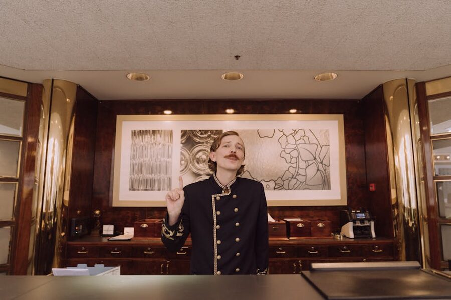 A hotel receptionist at a luxury front desk in uniform