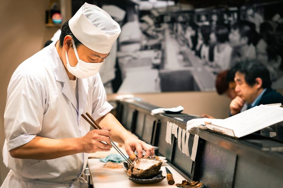 Sushi chef at a Tokyo restaurant counter preparing nigiri