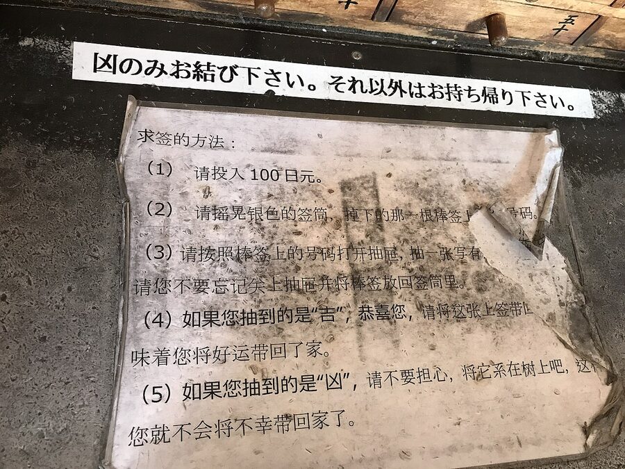 Omikuji tying rack with bad fortunes tied to wires at Senso-ji