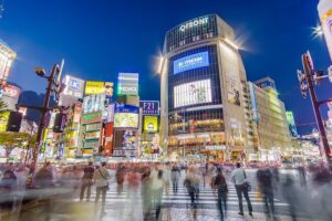 Aerial view of Shibuya Scramble Crossing at night with pedestrians flowing in all directions, Tokyo