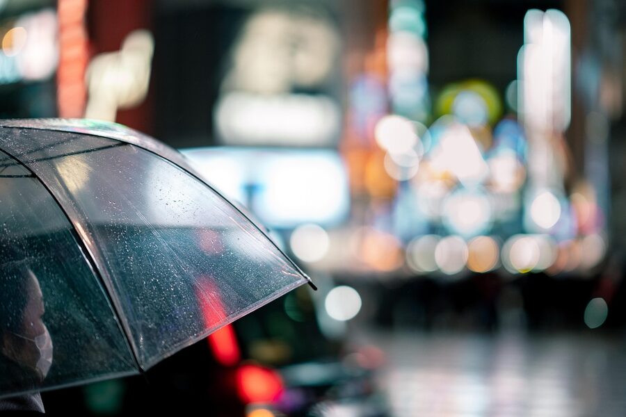 Pedestrians with umbrellas crossing Shibuya on a rainy night, Tokyo