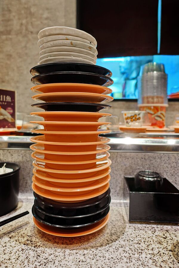 Stack of empty kaiten sushi plates at a conveyor belt restaurant