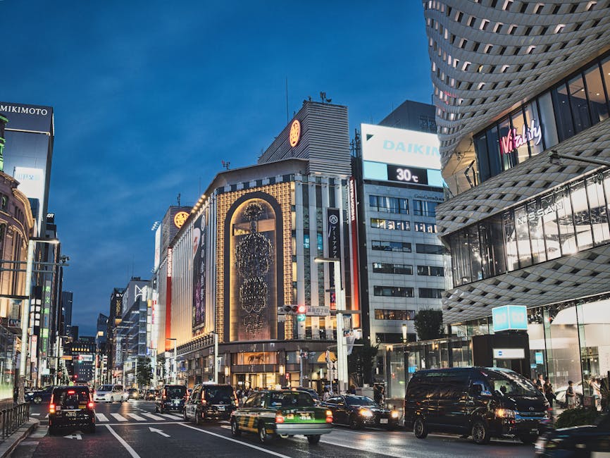 Wide evening avenue in Ginza with illuminated department stores