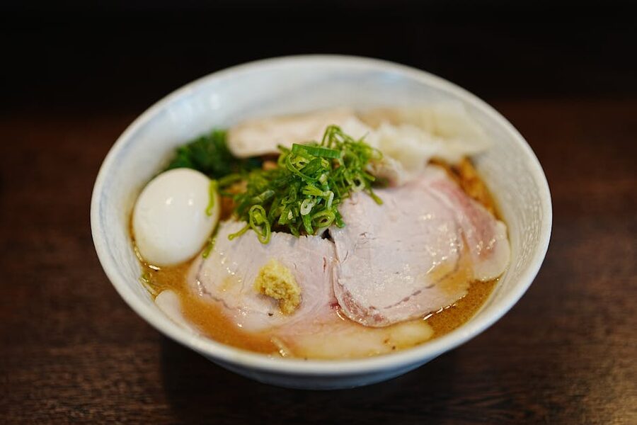 Close-up of a Japanese ramen bowl with egg, pork, and green onions