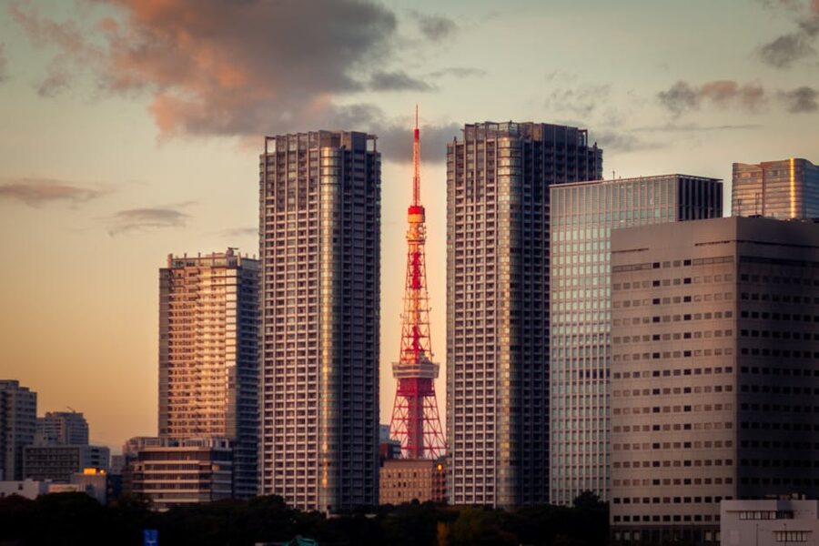 Tokyo Tower framed between modern Minato skyscrapers during sunset
