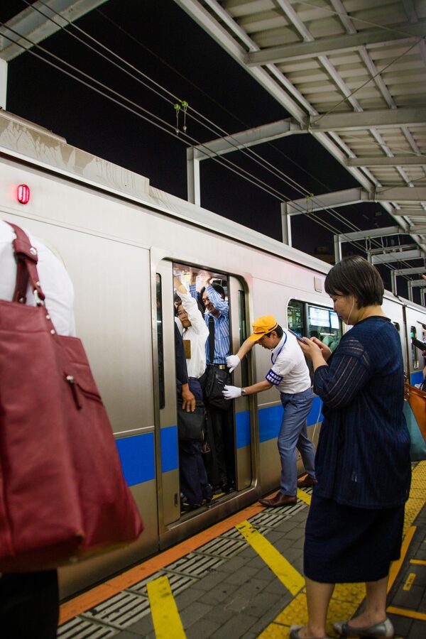 Shibuya Station platform at rush hour packed with commuters