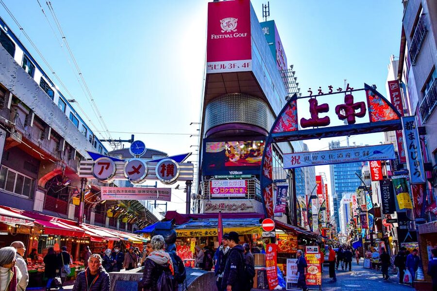 Crowded Ameyoko market street with food stalls and Japanese signage under the JR railway tracks, Ueno