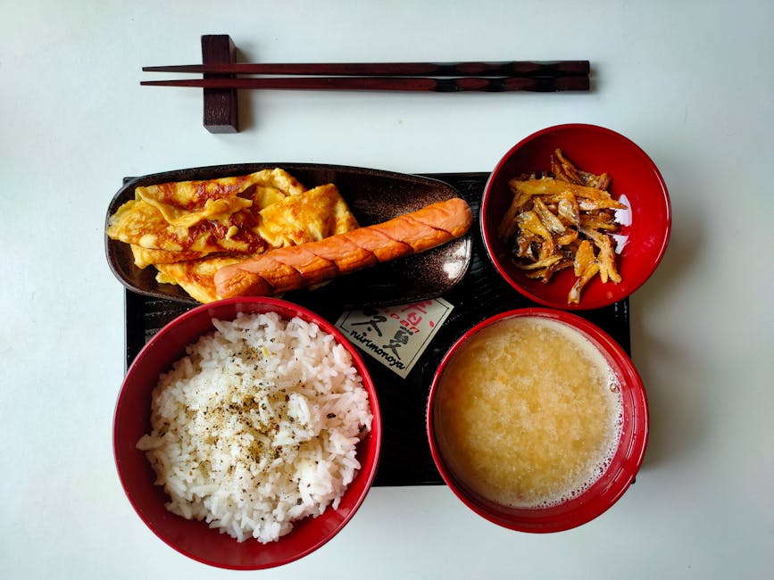 A traditional Japanese breakfast tray with rice, miso soup, grilled fish and small dishes