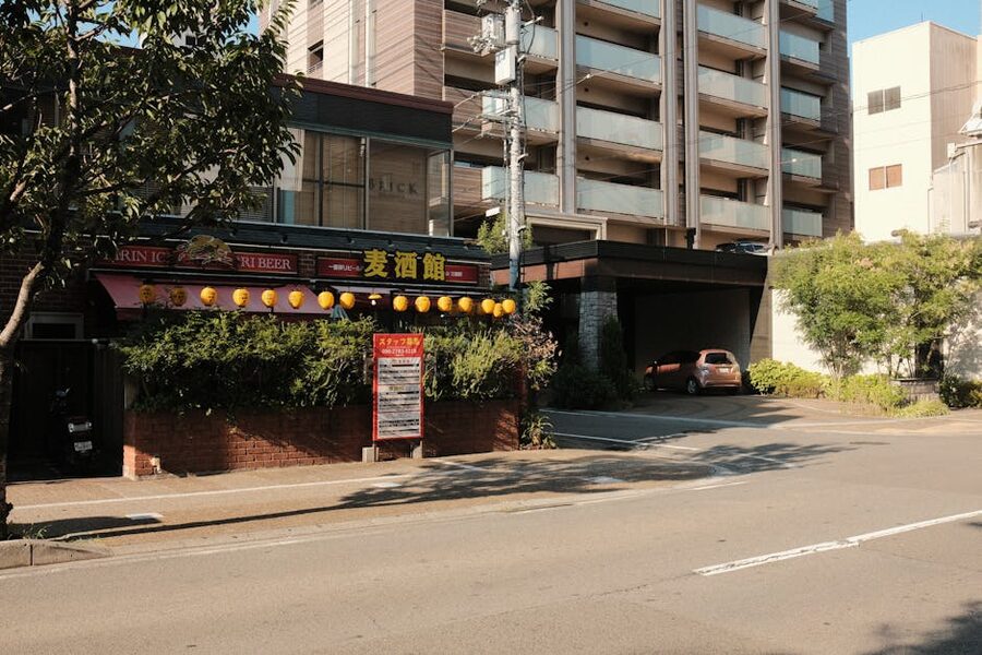 A Japanese izakaya exterior with hanging red and white lanterns at night